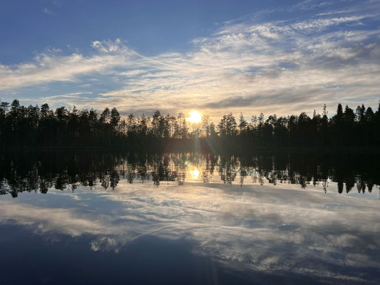 Wolken und Bäume spiegeln sich im ruhigen See
