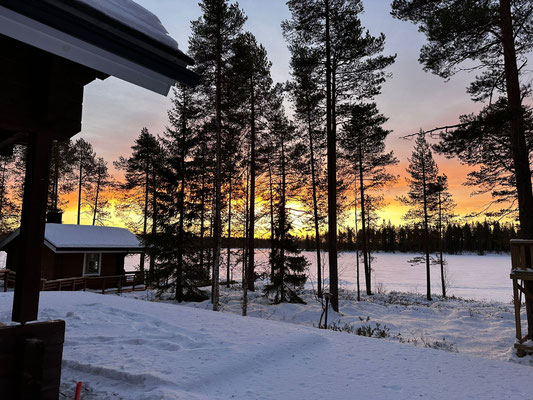 Holzterrasse mit Blick auf den winterlichen Sonnenuntergang