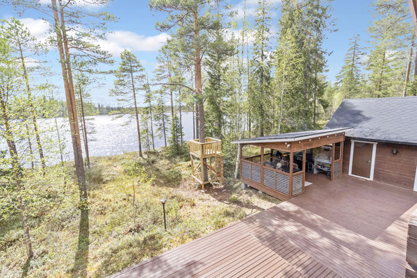 Holzterrasse und Gebäude zwischen Birken am See