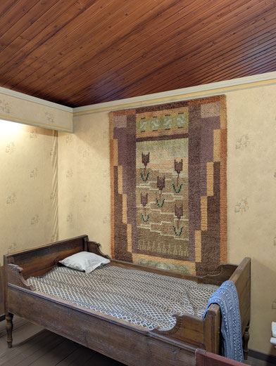 Lappländischer Wandteppich an einer Holzwand im Pentik-Museum