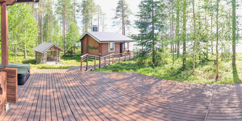 Holzgebäude hinter einer grossen Terrasse im Wald