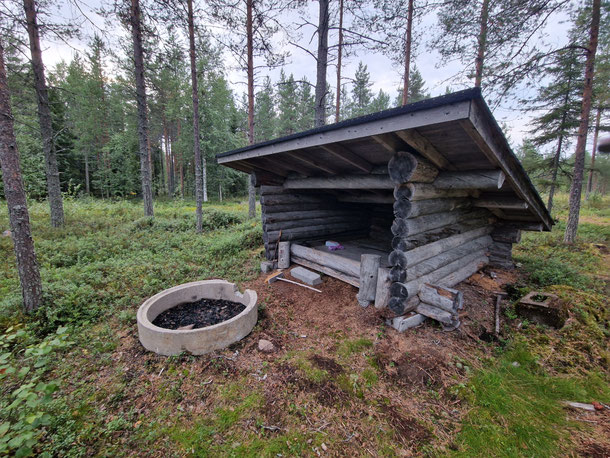 Kleiner Holzunterstand mit Feuerstelle im Wald