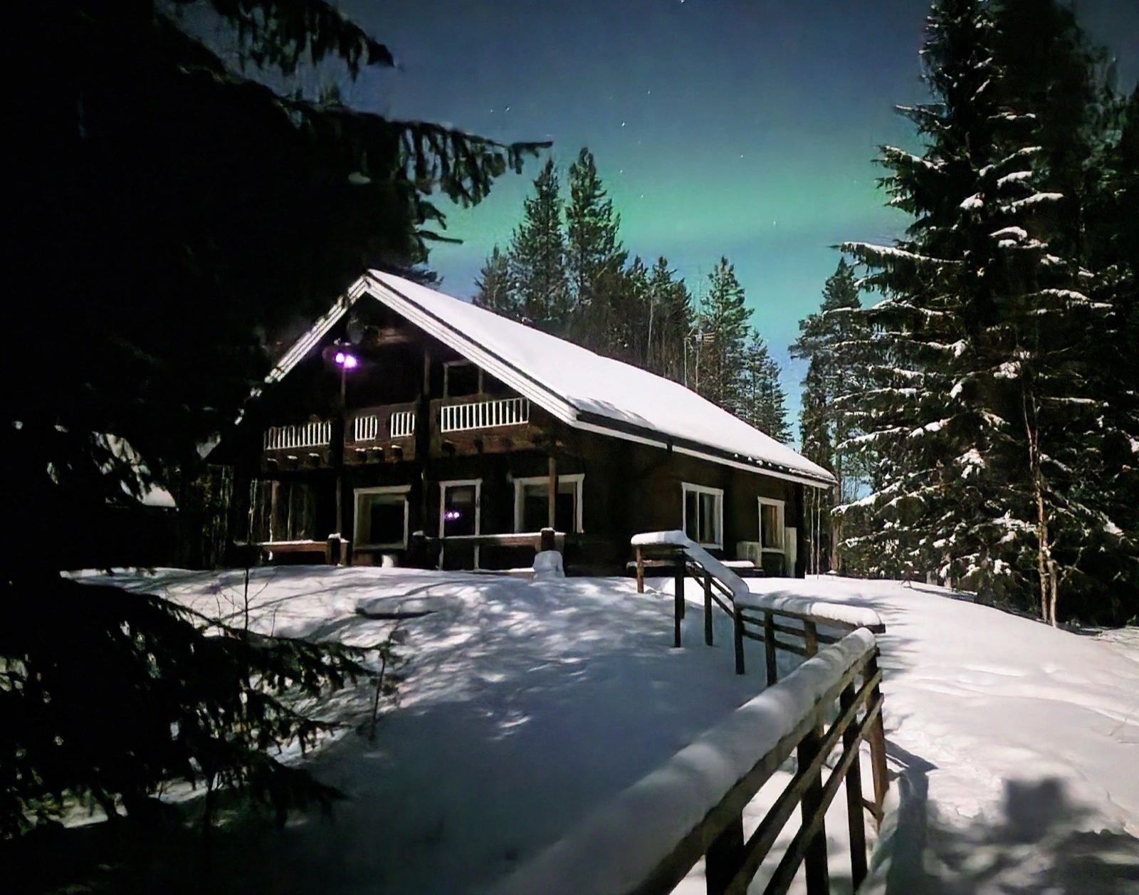 Nordlichter über dem Haupthaus von Mökki Tikka im Winter
