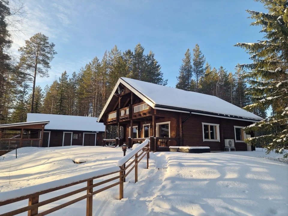 Blick vom verschneiten Weg hinauf zum grossen Blockhaus