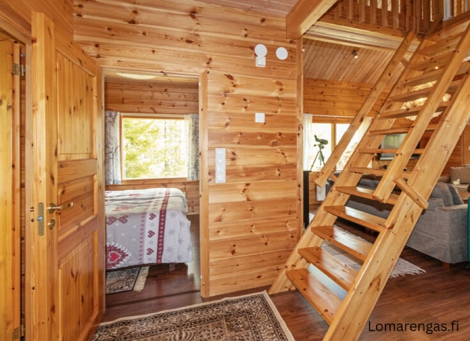 Holztreppe zur Galerie und Blick in das Schlafzimmer